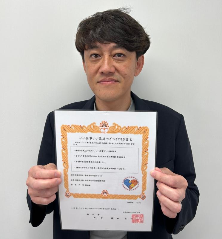 株式会社中央保険事務所の登録証を持った様子