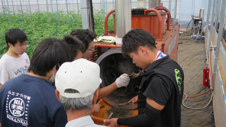 暖房機を掃除する学生